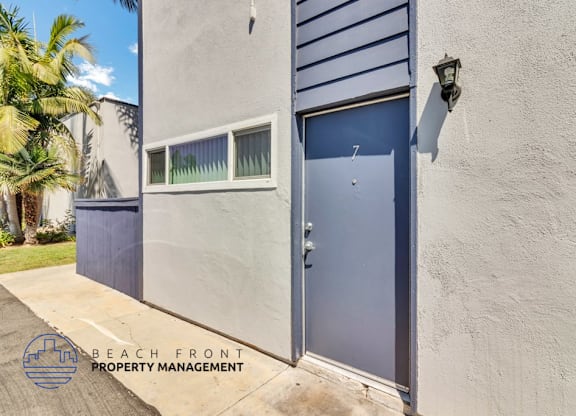A blue door is on the right side of a white wall.
