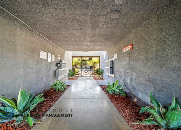 A concrete hallway with a red sign that says Front Management.