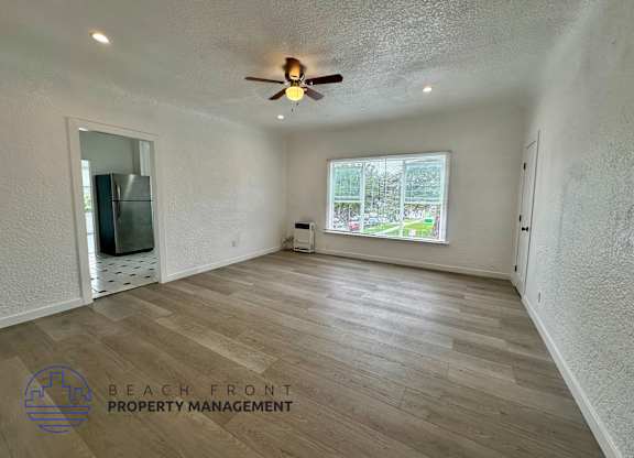 A room with a ceiling fan and wooden flooring.
