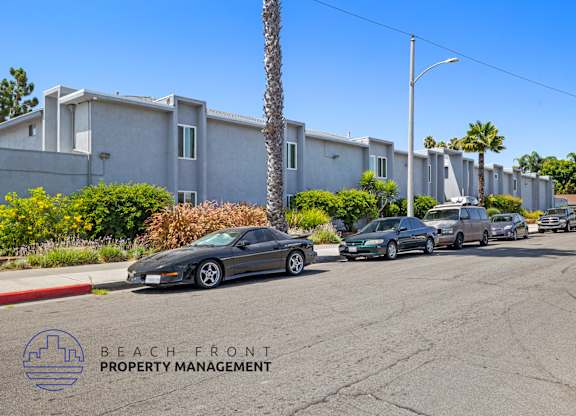 a row of cars parked on a street in front of a building