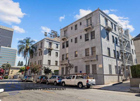 an old building on the corner of a street with parked cars