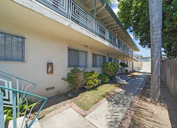 A white building with a balcony and a green chair.