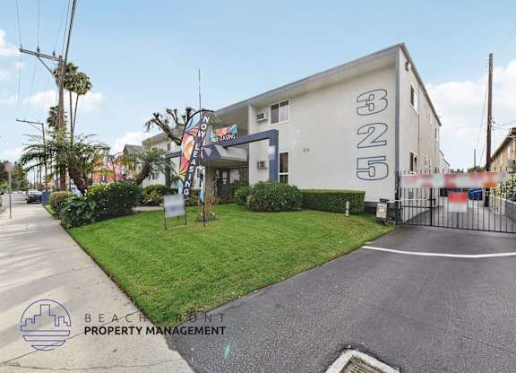 A white building with the number 5 on it is surrounded by a fence and has a sign that reads