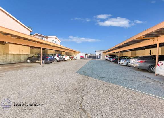 A parking lot with cars parked under a clear blue sky.