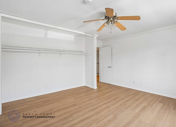A room with a ceiling fan and a door.