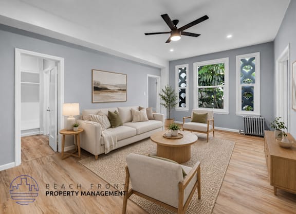 A living room with a couch, chairs, and a ceiling fan.