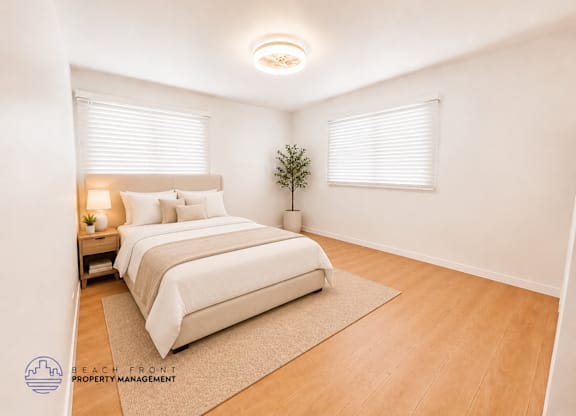 A bedroom with a bed, nightstand, and a plant.