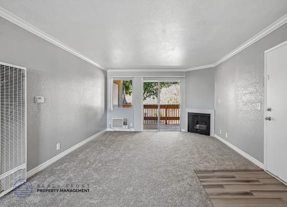 A spacious living room with a fireplace and a view of the backyard.