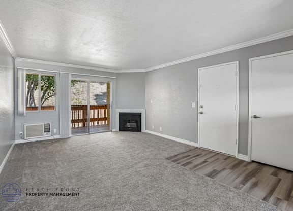 A spacious room with a fireplace and a view of the outdoors through a window.