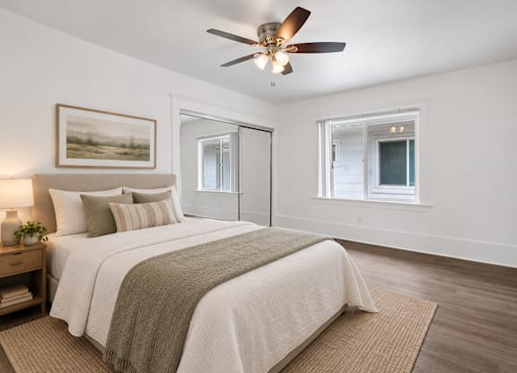 A bedroom with a large bed and a ceiling fan.