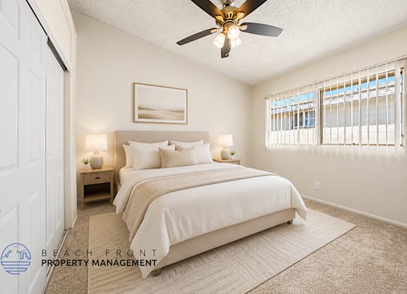 A bedroom with a large bed and a ceiling fan.