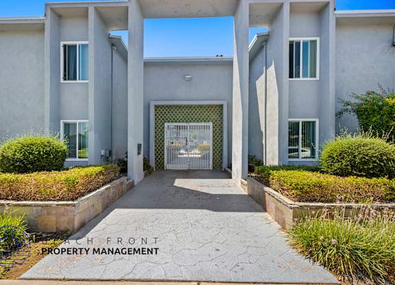 A modern building entrance with a clear sky in the background.