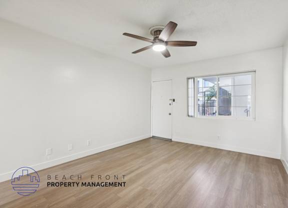 A room with a ceiling fan and wooden flooring.