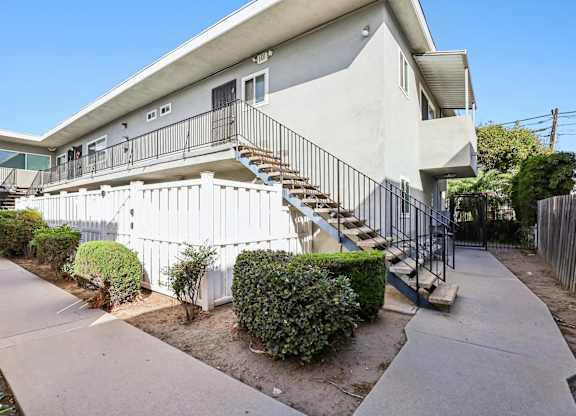 A white building with a black railing staircase.
