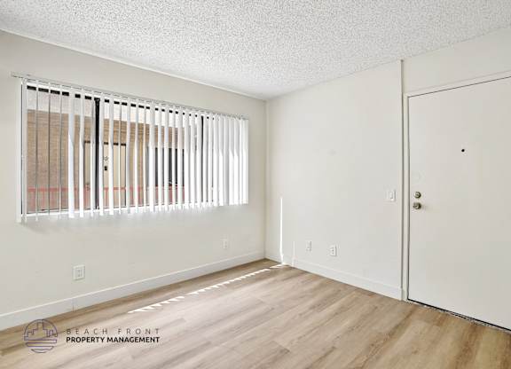 A room with a white door and a window with blinds.