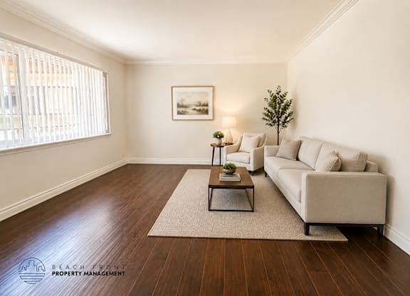 A living room with a couch, coffee table, and a painting on the wall.