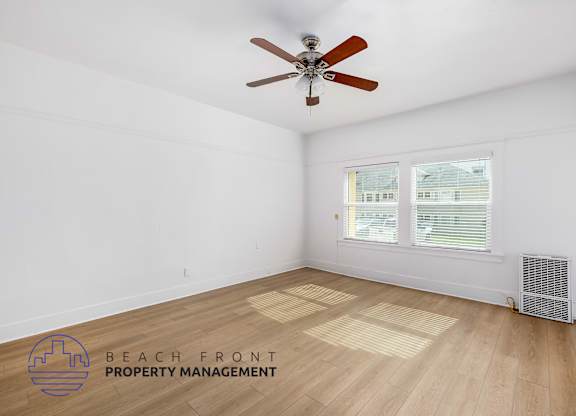 A room with a ceiling fan and a window with blinds.