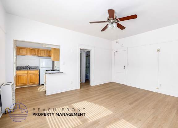 A spacious room with a ceiling fan and wooden flooring, managed by Beach Front Property Management.