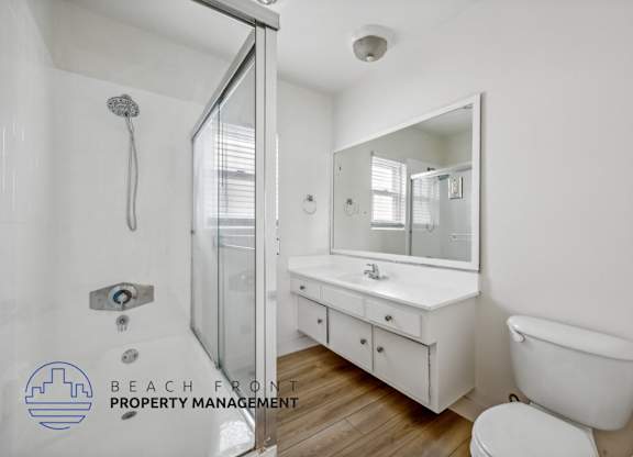A white bathroom with a toilet, sink, and bathtub.
