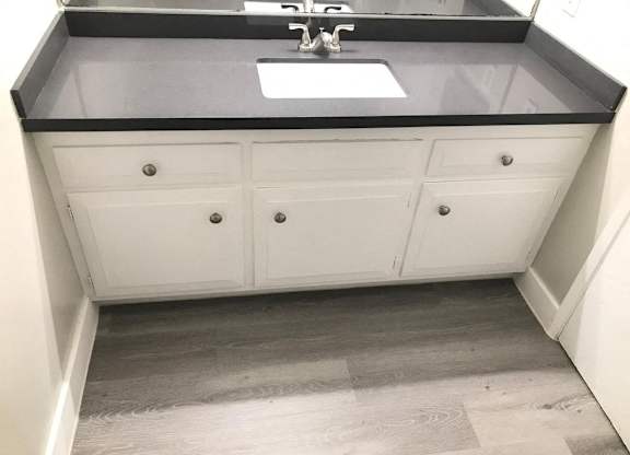 A bathroom with a sink and a cabinet.