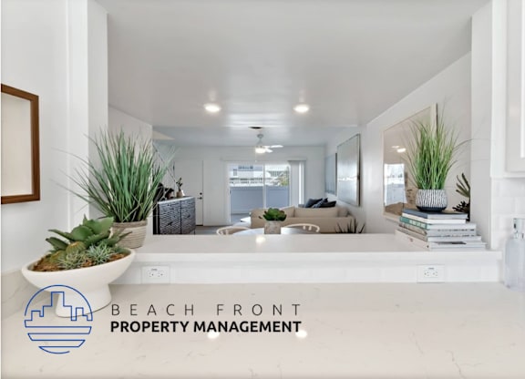 a view of a living room from the kitchen of a beach front property management advertisement