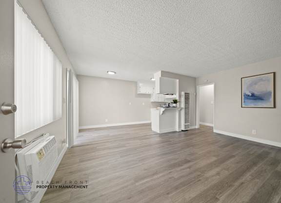 A spacious room with wooden flooring and a white cabinet.