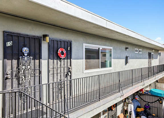 A balcony with a skeleton decoration and a wreath on the door.