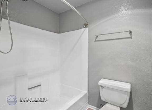 A white toilet in a bathroom with a white shower curtain.