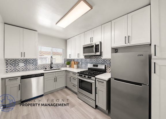 A modern kitchen with stainless steel appliances and white cabinets.