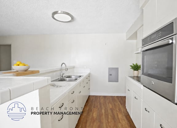 A modern kitchen with white cabinets and a stainless steel oven.