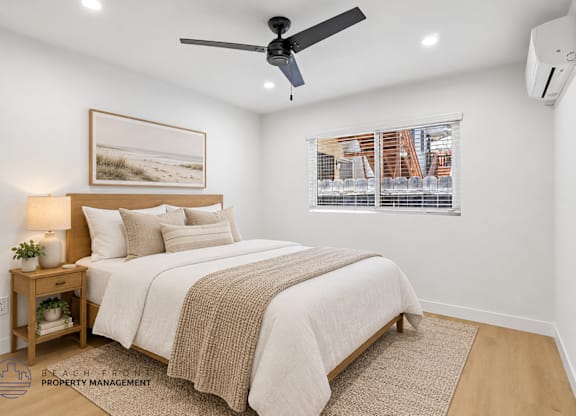 A bedroom with a bed, a ceiling fan, and a window with blinds.