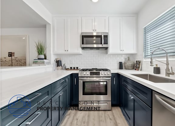 a kitchen with blue cabinets and white counter tops and a sink