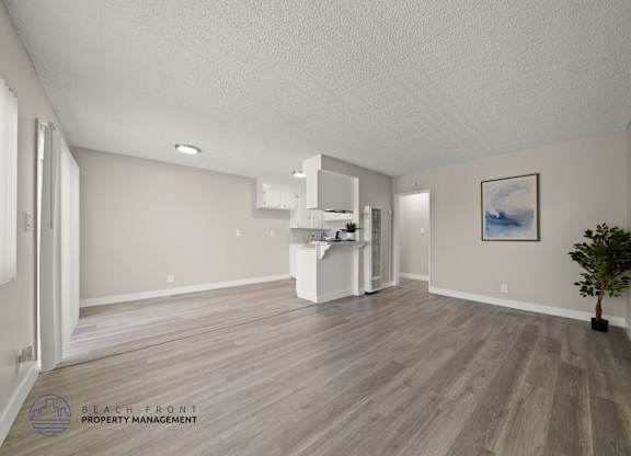 A spacious room with wooden flooring and a white cabinet.