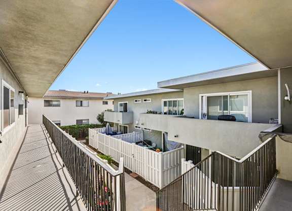 A balcony with a metal railing and a concrete floor.