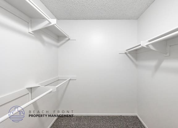 A white room with shelves and a logo for Beach Front Property Management.