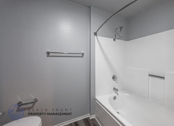A white bathroom with a shower and a bathtub.
