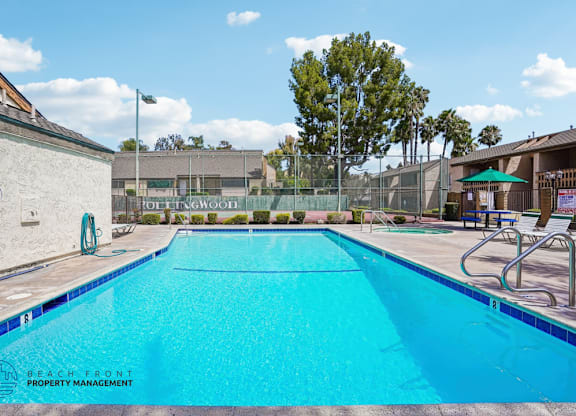 A swimming pool with a blue tiled edge and a white wall on the left.