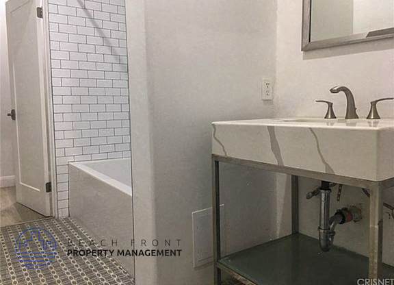 a bathroom with a sink and a tub and a mirror