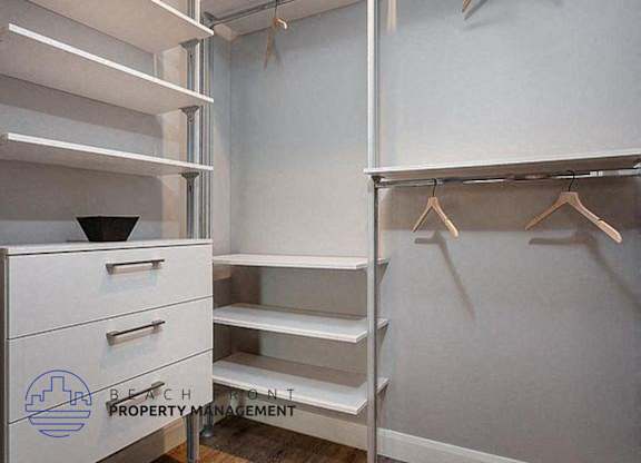a walk in closet with shelves and hangers