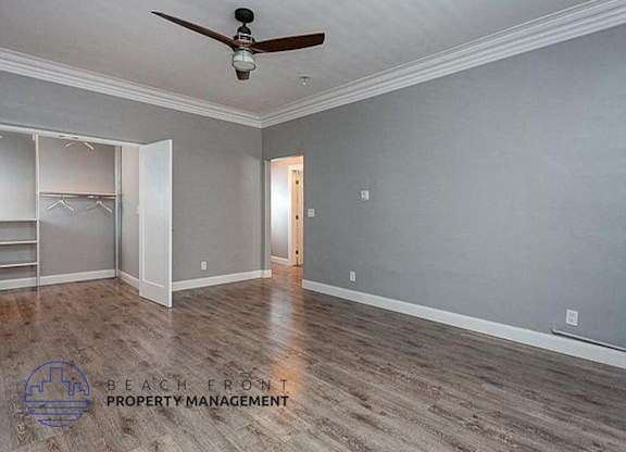 a empty room with a ceiling fan and a wood floor