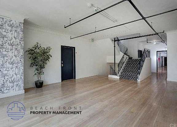 a large room with a staircase and a plant in it
