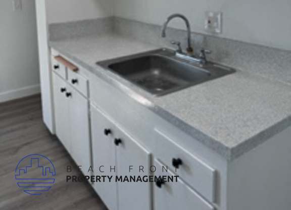 A kitchen with white cabinets and a granite countertop.