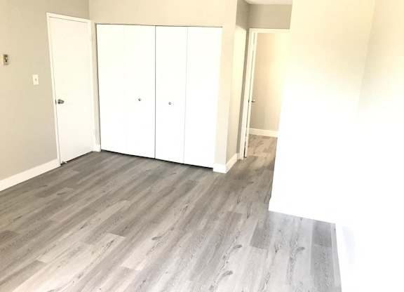 A room with a white door and a white wardrobe.