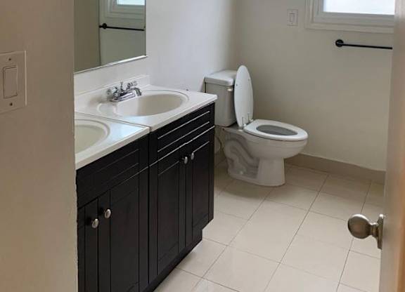 A bathroom with a sink, mirror, and a sign that says