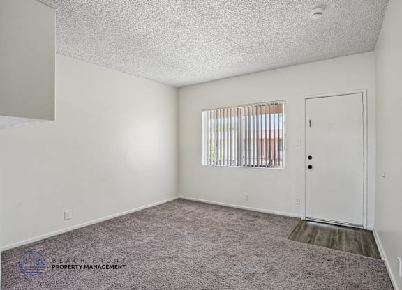 A room with a carpeted floor and a door.