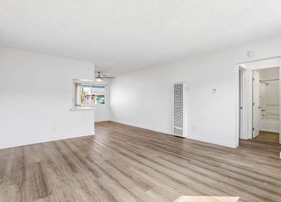 A room with wooden flooring and a window.