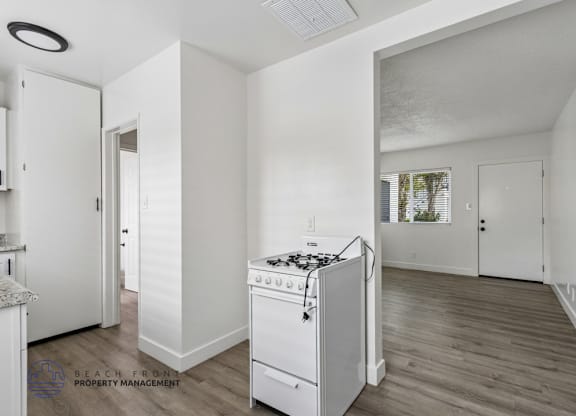 A white kitchen with a stove and a refrigerator.