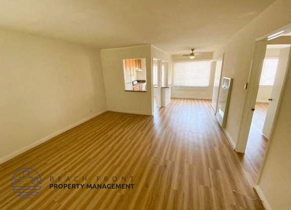 a empty living room and hallway with wood floors