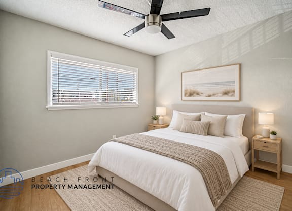 A bedroom with a bed, nightstands, and a ceiling fan.