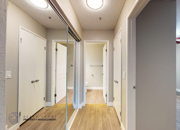A hallway with a wooden floor and white walls.